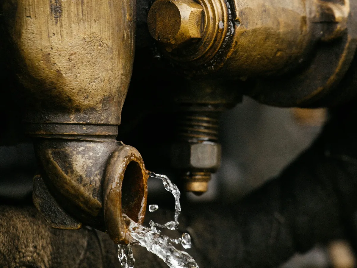 Agua saliendo de una válvula de bronce de una instalación antigua